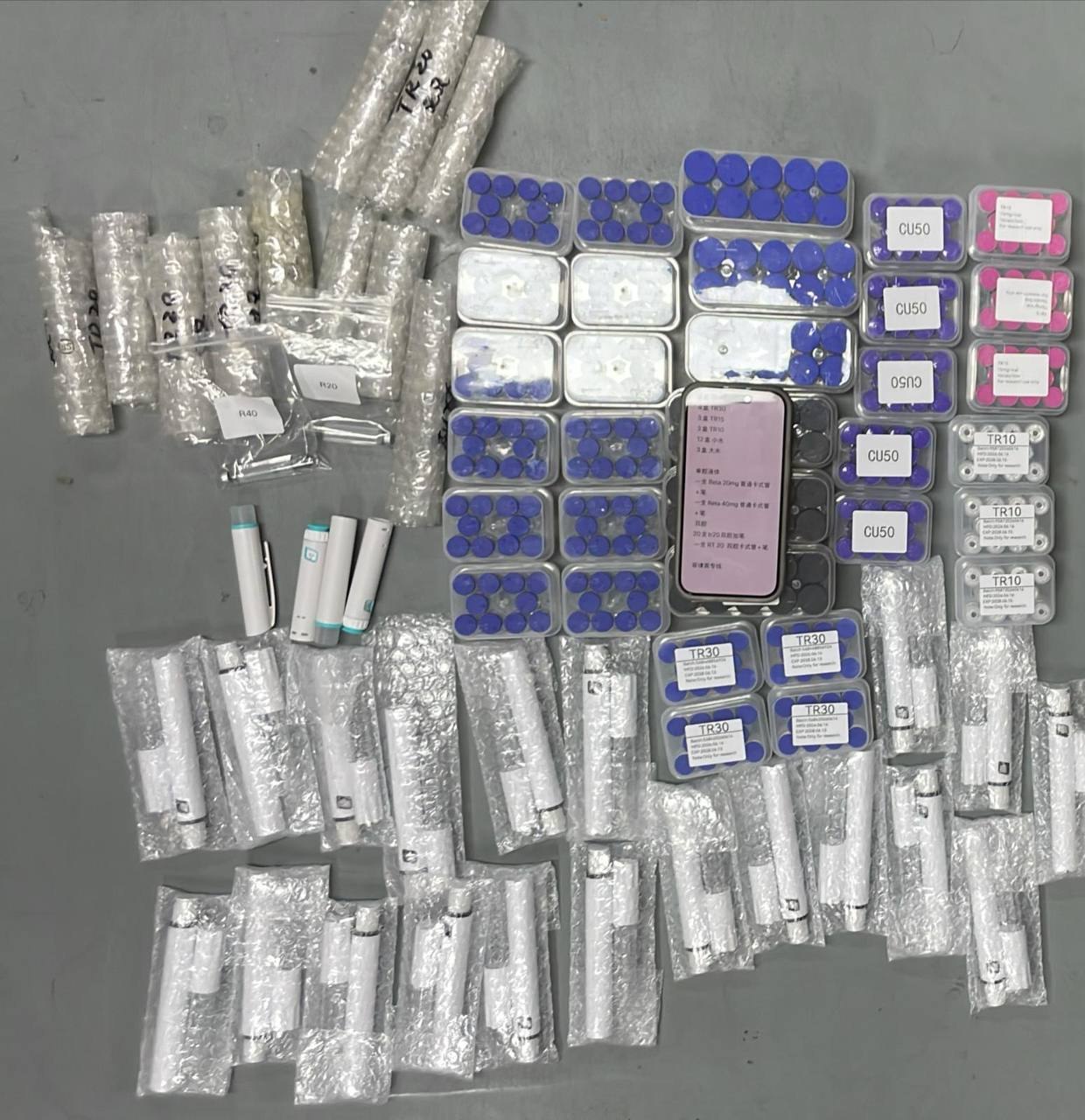 Large assortment of packaged products and vial trays on a packing surface